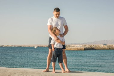 Baba ve oğul deniz tatilinde birlikte vakit geçiriyorlar. Genç adam, kumsalda yürüyen küçük çocuk babalar günü. Tek çocuklu bir aile. Babanızla mutlu bir çocukluk.