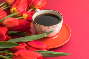 Bir buket kırmızı lale ve kahve fincanı düzenleme ve metin için bir sürü fotokopi alanı. Bahar havası. Doğum günü, Kadın, Anneler Günü, Düğün, Sevgililer Günü için tebrik kartı..