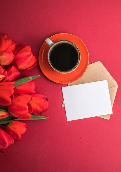 Bouquet of red  tulips and coffee cup arrangement with a lot of copy space for text. Spring mood concept. Greeting card for Birthday, Woman, Mother's Day, Wedding, Valentines day.