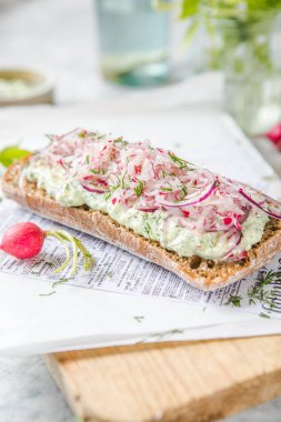 Açık arkaplanda krem peynirli ve turplu taze yeşil bahar sandviçi. Kopyalama alanı