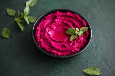 Humus Kasesi. Taze sebzeli kırmızı pancar humusu, masada zeytin yağı.