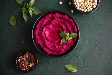 Humus Kasesi. Taze sebzeli kırmızı pancar humusu, masada zeytin yağı.