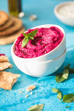 Humus Kasesi. Taze sebzeli kırmızı pancar humusu, masada zeytin yağı.