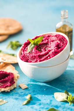 Humus Kasesi. Taze sebzeli kırmızı pancar humusu, masada zeytin yağı.