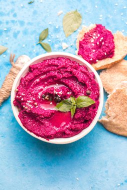 Humus Kasesi. Kırmızı pancar humus ve yassı ekmek, masada zeytinyağı.