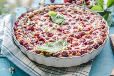 Mavi arka planda kirazlı vişneli Clafoutis.