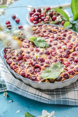 Mavi arka planda kirazlı vişneli Clafoutis.
