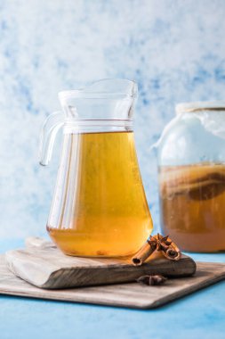 Çiğ mayalanmış ev yapımı alkolik ya da alkolsüz kombu çayı. Buzlu çay ve sağlıklı doğal probiyotik. Mavi arka planda naneli.