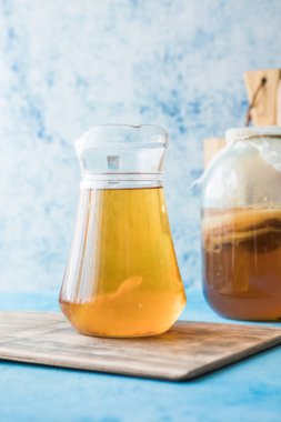 Çiğ mayalanmış ev yapımı alkolik ya da alkolsüz kombu çayı. Buzlu çay ve sağlıklı doğal probiyotik. Mavi arka planda naneli.