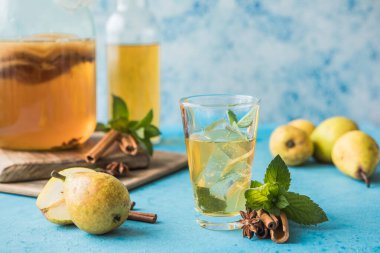 Çiğ mayalanmış ev yapımı alkolik ya da alkolsüz kombu çayı. Buzlu çay ve sağlıklı doğal probiyotik. Mavi arka planda naneli.