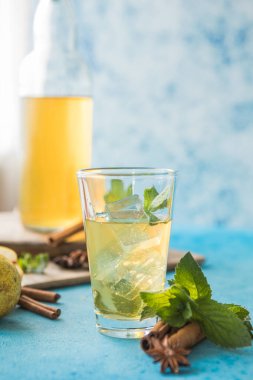 Çiğ mayalanmış ev yapımı alkolik ya da alkolsüz kombu çayı. Buzlu çay ve sağlıklı doğal probiyotik. Mavi arka planda naneli.