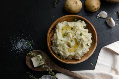 Köy arka planında çiğ patates ve baharatlı kremalı patates püresi.