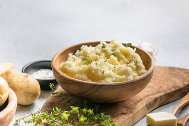 Köy arka planında çiğ patates ve baharatlı kremalı patates püresi.