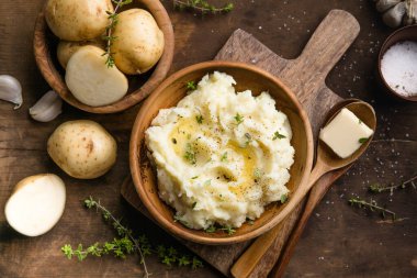 Köy arka planında çiğ patates ve baharatlı kremalı patates püresi.