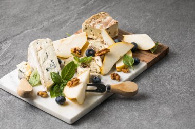 Taze armut kremalı Dor Mavi peynirle zarif mermer servis tahtasının üzerinde.