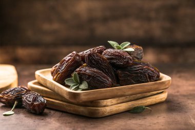 Tahta kasede sunulan doğal kurutulmuş hurma, vitamin ve lif açısından zengin sağlıklı tatlı meyve.