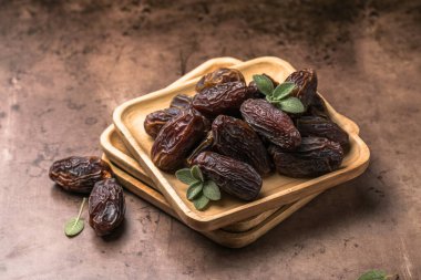 Tahta kasede sunulan doğal kurutulmuş hurma, vitamin ve lif açısından zengin sağlıklı tatlı meyve.