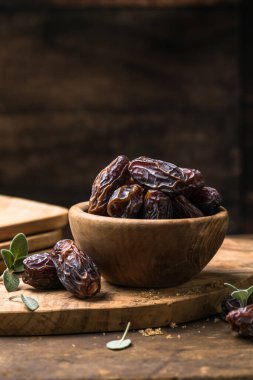 Tahta kasede sunulan doğal kurutulmuş hurma, vitamin ve lif açısından zengin sağlıklı tatlı meyve.