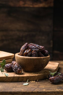 Tahta kasede sunulan doğal kurutulmuş hurma, vitamin ve lif açısından zengin sağlıklı tatlı meyve.