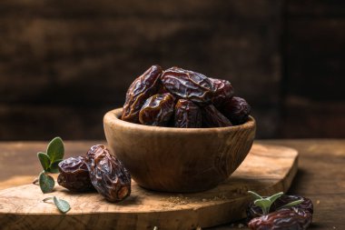 Tahta kasede sunulan doğal kurutulmuş hurma, vitamin ve lif açısından zengin sağlıklı tatlı meyve.