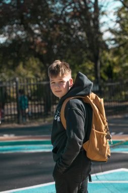 Sırt çantalı 10 yaşında bir çocuk Amerikan okulundan eve yürüyor, doğal gündüz fotoğrafı..