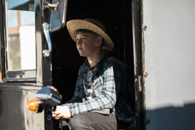 Amiş çocuklar geleneksel bir at arabasında birlikte oturuyorlar..