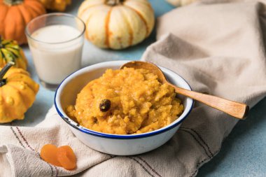 Kayısı ve kuru üzümlü ev yapımı balkabağı lapası mavi arka planda sıcak sonbahar kahvaltısı.