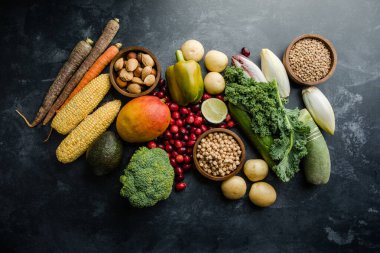 Taze besin yoğunluğundaki bileşenlerin üst görünümü. A, C, K ve B vitaminleri, antioksidan ve lif açısından zengin bitkisel gıdaların renkli bir koleksiyonu.