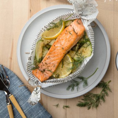 Kavrulmuş kuşkonmaz ve mevsimlik sebzelerle servis edilen sağlıklı pişmiş somon. Temiz yemek, dengeli beslenme, ev yemeği konsepti..