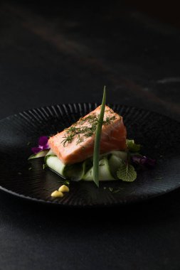 Saku usulü taze çiğ somon, siyah bir tabakta servis edilir. Minimalist Japon kaynaklı gıda sunumu.