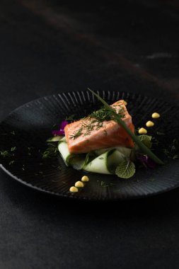 Saku usulü taze çiğ somon, siyah bir tabakta servis edilir. Minimalist Japon kaynaklı gıda sunumu.