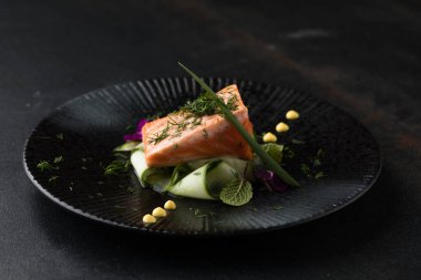Saku usulü taze çiğ somon, siyah bir tabakta servis edilir. Minimalist Japon kaynaklı gıda sunumu.