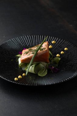 Saku usulü taze çiğ somon, siyah bir tabakta servis edilir. Minimalist Japon kaynaklı gıda sunumu.