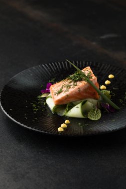 Saku usulü taze çiğ somon, siyah bir tabakta servis edilir. Minimalist Japon kaynaklı gıda sunumu.