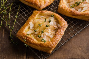 Beyaz tabakta mükemmel bir tatlı olarak servis edilen, yumuşak pastaya sarılmış altın fırında armut..