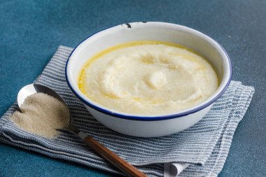 Mavi masada kahvaltı için eski bir kasede Semolina lapası.