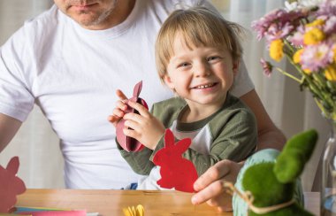 Baba ve 3 yaşındaki oğlu evde birlikte paskalya tavşanı yapıyorlar.