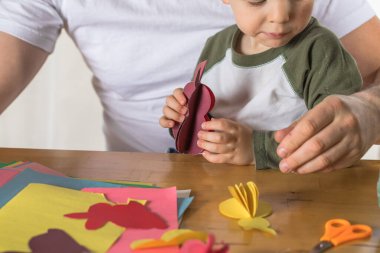 Baba ve 3 yaşındaki oğlu evde birlikte paskalya tavşanı yapıyorlar.