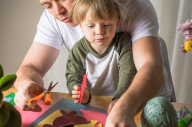 Baba ve 3 yaşındaki oğlu evde birlikte paskalya tavşanı yapıyorlar.