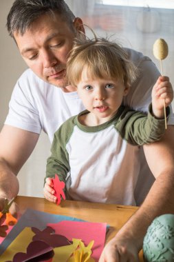 Baba ve 3 yaşındaki oğlu evde birlikte paskalya tavşanı yapıyorlar.
