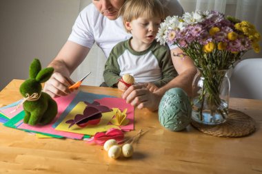 Baba ve 3 yaşındaki oğlu evde birlikte paskalya tavşanı yapıyorlar.
