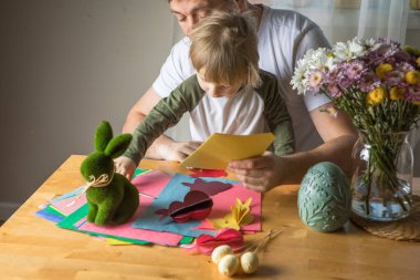 Baba ve 3 yaşındaki oğlu evde birlikte paskalya tavşanı yapıyorlar.