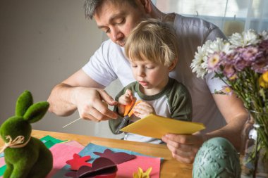 Baba ve 3 yaşındaki oğlu evde birlikte paskalya tavşanı yapıyorlar.