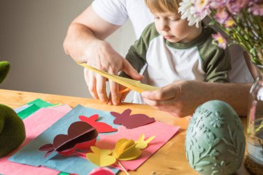 Baba ve 3 yaşındaki oğlu evde birlikte paskalya tavşanı yapıyorlar.