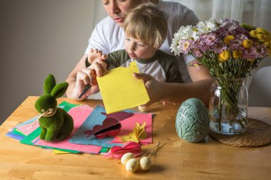 Baba ve 3 yaşındaki oğlu evde birlikte paskalya tavşanı yapıyorlar.