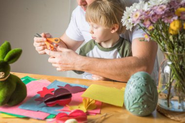 Baba ve 3 yaşındaki oğlu evde birlikte paskalya tavşanı yapıyorlar.