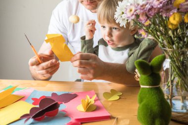 Baba ve 3 yaşındaki oğlu evde birlikte paskalya tavşanı yapıyorlar.