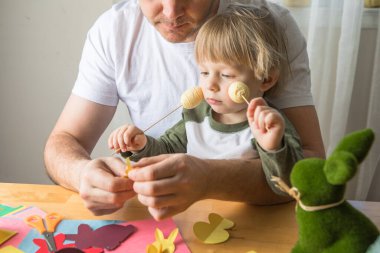 Baba ve 3 yaşındaki oğlu evde birlikte paskalya tavşanı yapıyorlar.