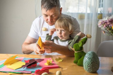 Baba ve 3 yaşındaki oğlu evde birlikte paskalya tavşanı yapıyorlar.