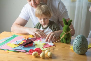 Baba ve 3 yaşındaki oğlu evde birlikte paskalya tavşanı yapıyorlar.